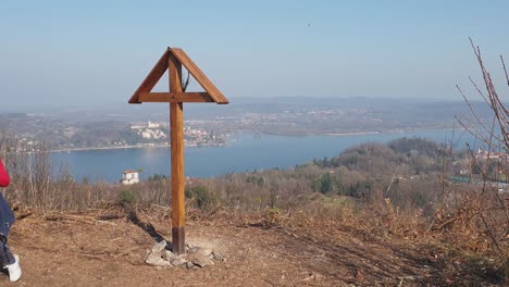 Anciana-Con-Palos-De-Madera-Para-Hacer-Trekking-En-La-Próxima-Cruz-En-El-Mirador-De-Motta-Grande-En-Arona,-Italia