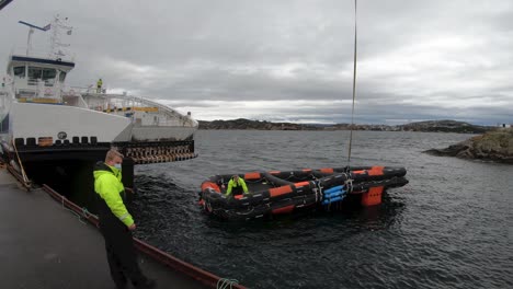 Ships-Liferaft-beeing-towed-alongside-with-crane-after-live-testing-of-rescue-equipment-in-dark-windy-weather