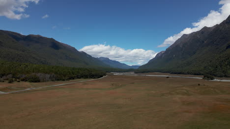 Large-vast-open-grass-field-between-the-mountains-in-Fiordland-Southland,-New-Zealand