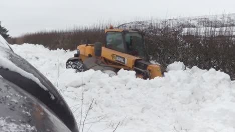 A-farmer's-JCB-telehandler-makes-easy-work-of-clearing-deep-snowdrifts-which-have-blocked-a-narrow-road-overnight