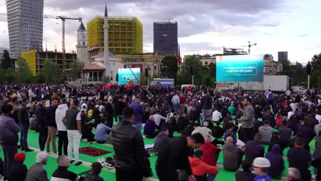 Religious-people-sitting-on-square-in-front-of-mosque,-waiting-Eid-praying-in-Tirana