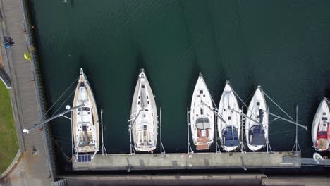 Sailboats-moored-in-marina-Solheimsviken-in-Bergen-Norway---Aerial-forward-moving-top-down-view
