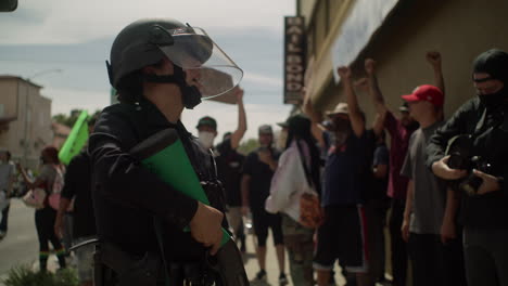 Female-Police-officer-armed-with-a-shotgun-during-a-protest-in-front-of-the-city-hall