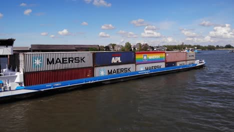 Containergüter,-Die-Auf-Den-Frachter-Geladen-Werden,-Der-Auf-Den-Gewässern-Des-Dorfes-Kinderdijk-Segelt