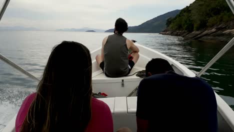 Vista-Posterior-De-Personas-Navegando-En-Lancha-Motora-En-La-Bahía-Rodeada-De-Montañas-En-Paraty,-Brasil