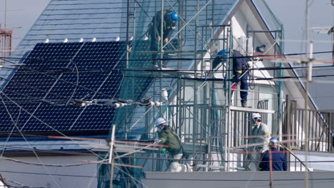 Blue-collar-Workers---Construction-Workers-On-Scaffoldings-Working-On-Rooftop-Of-Building-During-Pandemic-In-Tokyo,-Japan