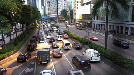 Busy-traffic-jam-on-main-highway-road-surrounded-by-tall-skyscrapers-towering-row-in-major-modern-Asia-financial-hub-in-Hong-Kong,-China