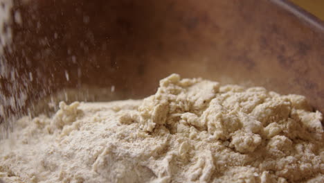 BAKING---Sprinkling-flour-during-sourdough-bread-baking,-slow-motion-pan-right