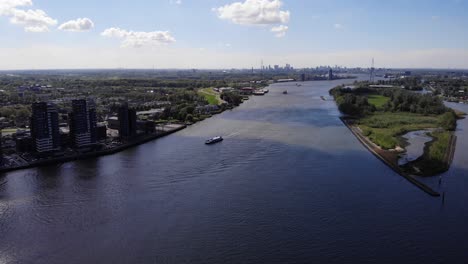 Aerial-View-Of-Boat-Cruising-At-Nieuwe-Maas-River-Near-Kinderdijk-In-Netherlands