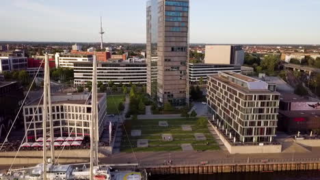 Vista-Aérea-Que-Muestra-El-Paisaje-Urbano-De-Bremen-Con-Edificios-Modernos-Y-Barco-Anclado-En-El-Muelle-Durante-El-Día-Soleado,-Alemania