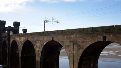 Public-train-crossing-Runcorn-bridge-old-castle-turret-building-tower-left-to-right-journey