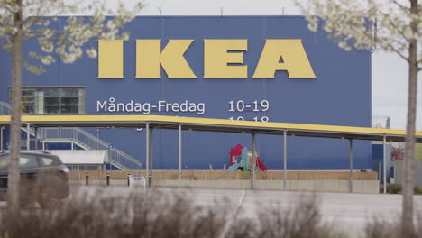 A-car-leaves-an-empty-IKEA-car-park-in-Borlange,-Sweden