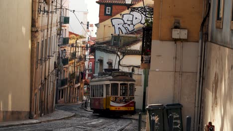 Un-Encantador-Tranvía-Amarillo-Atraviesa-Una-Calle-Estrecha-En-Lisboa,-Portugal