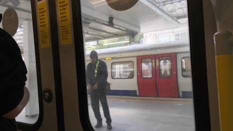 Las-Puertas-Del-Tren-Subterráneo-De-La-Línea-Circle-Del-Distrito-De-Londres-Se-Abren-A-La-Estación-De-Earls-Court-Roundel