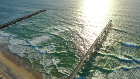 Slow-Motion-pan-at-sunrise,-drone-view-of-Seawall-and-Jetty