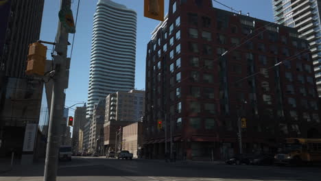 Wide-shot-with-yellow-school-bus-travelling-through-the-intersection-at-Carlton-and-Jarvis-in-Toronto