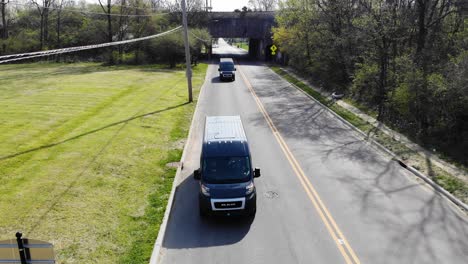 Amazon-delivery-vans-drive-down-a-city-street-recorded-by-an-aerial-drone