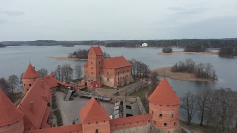 Antena:-Castillo-De-La-Isla-De-Trakai-Y-Ondeando-La-Bandera-De-Lituania-Con-Lago-Y-Bosque-En-El-Fondo