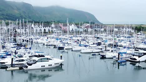 Luxury-yachts-and-sailboats-parked-on-misty-mountain-range-retirement-village-Conwy-marina-zoom-out