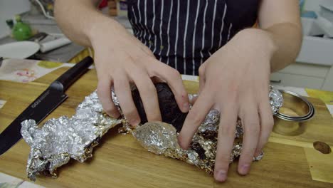 El-Chef-Desenvuelve-La-Remolacha-Horneada-Del-Papel-De-Aluminio-En-La-Mesa-De-La-Cocina,-Cierra-La-Cámara-Lenta