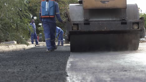 Arbeiter-Pflastern-Eine-Ländliche-Straße-In-Corumba,-Brasilien---Heißer-Dampf-Steigt-Vom-Frisch-Gepressten-Asphalt-Auf