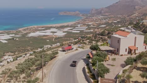 Majestic-slope-side-road-to-Falasarna-beach-in-Crete-island,-aerial-drone-view