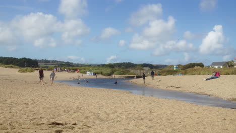 La-Gente-Se-Relaja,-Camina-Y-Nada-En-El-Río-Rojo-En-La-Playa-De-Marazion-En-Un-Día-Soleado-De-Verano,-Cornwall