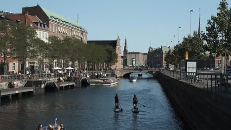 Blick-Auf-Die-Altstadt-Von-Kopenhagen-Mit-Menschen,-Die-Wassersport-Im-Kanal-Genießen