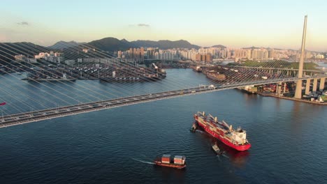 Großes-Containerschiff,-Das-Die-Bucht-Von-Hongkong-Unter-Der-Steinmetzbrücke-Verlässt,-Luftbild