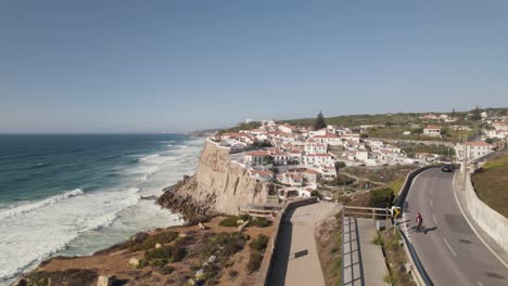 Gente-Caminando-Por-La-Pasarela-A-Lo-Largo-Del-Acantilado-Junto-Al-Mar,-Carretera-Costera-Cerca-De-Azenhas-Do-Mar,-Portugal