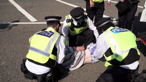 Police-officers-search-a-handcuffed-arrested-male-protestor-on-the-ground-during-protests-against-the-Defence-and-Security-Equipment-International-exhibition