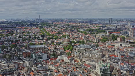 Amsterdam-Netherlands-Aerial-v5-drone-pan-shot-across-downtown-capturing-populous-cityscape-with-traditional-and-modern-townhouse-buildings-and-iconic-historic-architectures---August-2021
