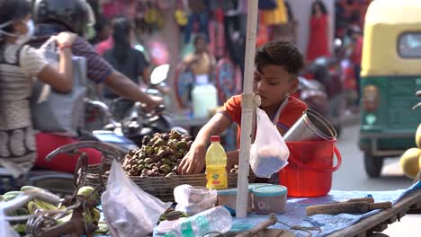 Pobre-Niño-Huérfano-Vendedor-De-Frutas-Vendiendo-Frutas-En-La-Calle,-Vehículos-Que-Pasan