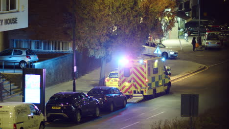 Ambulancia-De-Londres-Con-Luces-Parpadeantes-Estacionada-En-Una-Calle-Por-La-Noche