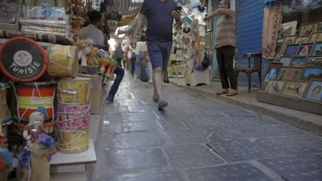 Eckladen-Mit-Lokalen-Produkten-Und-Touristen,-Die-Auf-Dem-öffentlichen-Markt-In-Tunesien-Einkaufen-Gehen