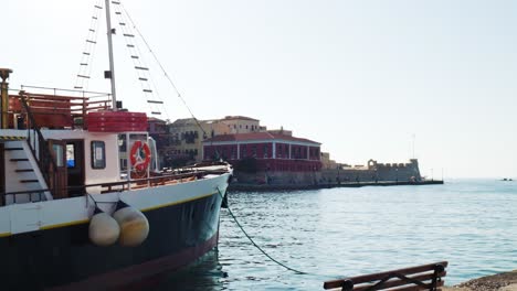 historic-old-boat-in-Chania-Crete,-Scenic-Historical-view-over-Greek-Waterfront-Old-Town-Harbour,-Tourists-Sightseeing-on-Sunny-Summer-Day-in-Greece