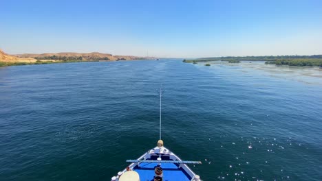 Front-bow-of-a-cruise-ship-sailing-through-Nile-River-on-a-blue-sky-day