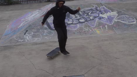 Slow-mo-of-skate-boarder-dress-in-black-at-a-skate-park-in-Sheffield,-England-doing-a-trick-but-not-quite-landing-it
