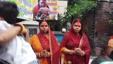 Close-up-shot-of-two-Indian-women's-standing-inside-the-water-performing-chatt-puja-in-Kolkata