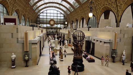 Main-gallery-in-the-Orsay-museum-in-Paris-with-visitors-and-multiple-art-pieces