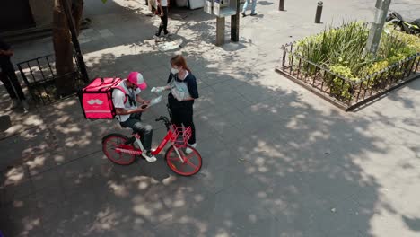 Aerial-low-altitude-above-doctor-actor-speaking-to-people-at-public-plaza