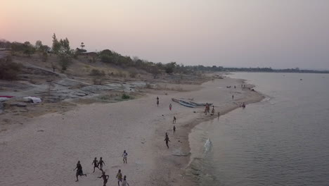 Alegres-Niños-Tumbuka-Corren-Hacia-Drones-En-La-Orilla-Del-Lago-Malawi