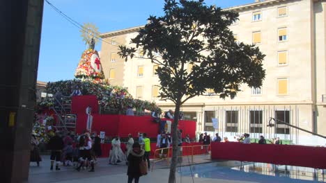 Fiestas-Del-Pilar---Cola-De-Gente-Con-Traje-Tradicional-Dejando-Flores-En-La-Estatua-De-La-Virgen-María-En-La-Plataforma-De-La-Plaza-Del-Pilar-En-Zaragoza,-Aragón,-España