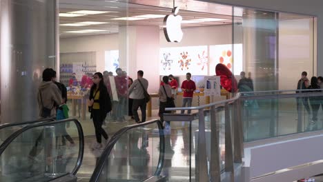 Menschen-Gehen-Am-Offiziellen-Apple-Store-Und-Logo-Der-Multinationalen-Amerikanischen-Technologiemarke-In-Einem-Einkaufszentrum-In-Hongkong-Vorbei