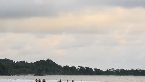 Man-riding-on-a-horse-along-a-beach-during-sunset