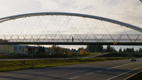 Person-walking-across-bridge-over-Highway-1-in-Abbotsford,-BC,-with-one-lane-closed-during-BC-flooding