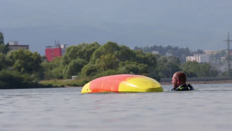 Man-struggles-in-water-in-an-upside-down-capsized-kayak