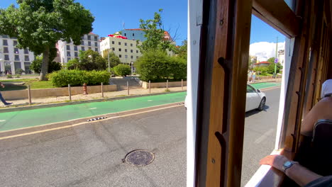 Los-Turistas-Visitan-La-Arquitectura-De-La-Calle-Lisboa-A-Través-De-Las-Ventanas-Abiertas-Del-Recorrido-En-Tranvía-Antiguo-Durante-El-Día-Cuando-Pasa-El-Automóvil