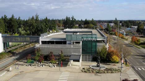 Parking-Garage-And-Train-Platform-At-Lakewood-Station,-Pacific-Highway-Southwest-Lakewood,-Washington,-United-States---aerial-drone-shot