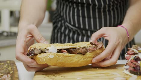 Der-Koch-Beendet-Die-Zubereitung-Von-Rindfleischsandwiches-Auf-Einem-Holzschneidebrett